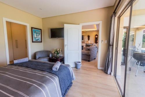 a bedroom with a bed and a living room at Serenity, Cathkin Estates by Euphoric Leisure in Winterton