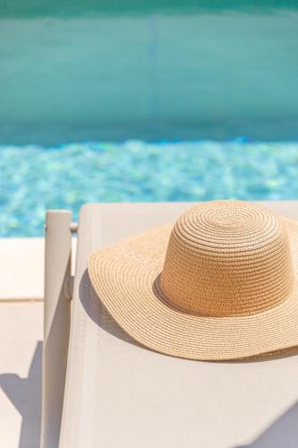 a straw hat sitting on the edge of a boat at Kefalas Luxury Villas Patitiri with Private Pool in Epáno Kefalás