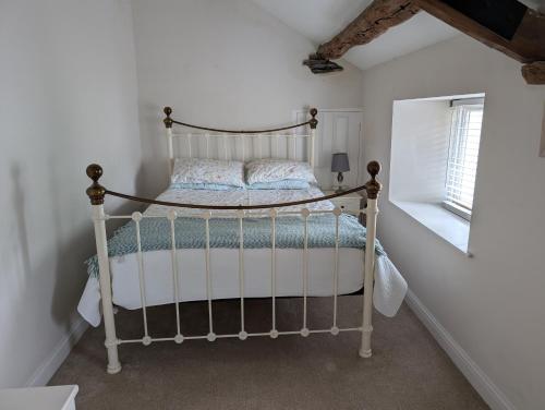 a bedroom with a metal bed in a room at Garth Nook Barn in Soutergate
