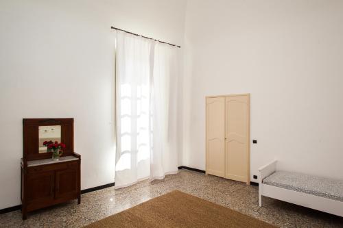 a bedroom with a bed and a dresser and a window at Casa Carducci - Spacious historical home close to the beach in Imperia