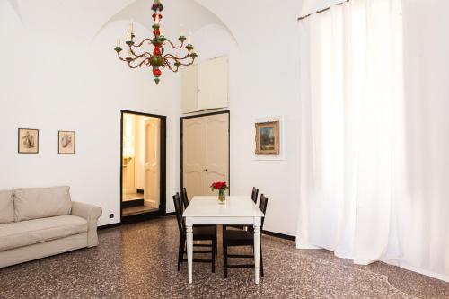 a living room with a white table and a chandelier at Casa Carducci - Spacious historical home close to the beach in Imperia
