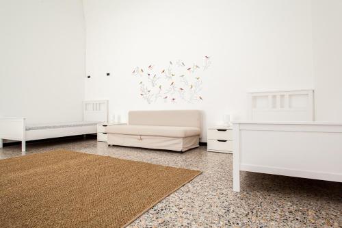 a white bedroom with two beds and a rug at Casa Carducci - Spacious historical home close to the beach in Imperia