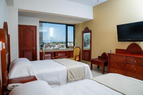 a hotel room with two beds and a flat screen tv at Vallarta Live Hotel in Puerto Vallarta