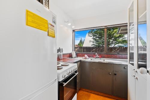 a kitchen with a stove and a window at 43 Conical Hill Road in Hanmer Springs