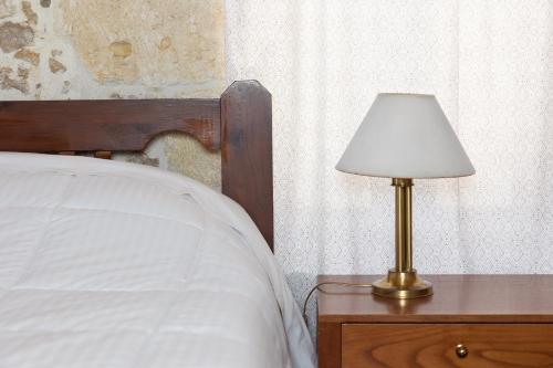 a lamp on a night stand next to a bed at Petra & fos in Bendevís
