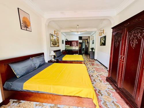 a bedroom with two beds with yellow sheets at IL Divo Hostel & Spa Hàng Đào in Hanoi