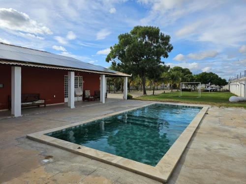 a swimming pool in front of a house at Chácara Urbana in Juazeiro
