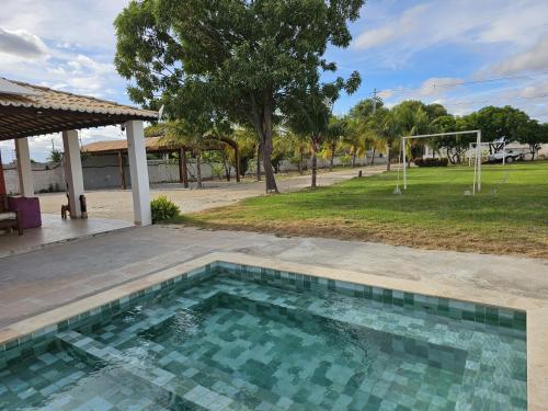 a swimming pool in front of a park at Chácara Urbana in Juazeiro