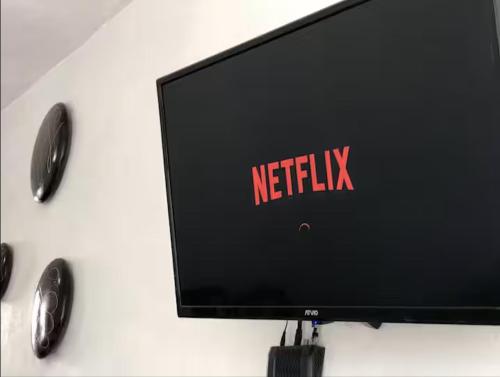 a television with a netflix sign on a wall at CASA DORADO A con AC Y SMART TV Planta Alta in Mezcales