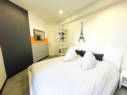 une chambre avec un lit blanc et une tour Eiffel dans l'établissement Apartment Residence of Stade de France, à Saint-Denis