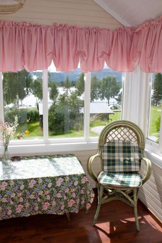 a room with a chair and a table and a window at Nedre Strand Hytteutleie in Vradal