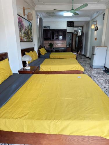 a room with three beds with yellow sheets at IL Divo Hostel & Spa Hàng Đào in Hanoi