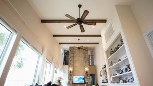 a ceiling fan in a living room with a fireplace at Joy House in Imari