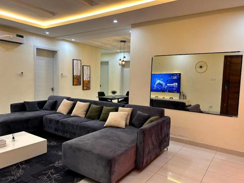 a living room with a couch and a large mirror at Granduer Apartment in Maiyegun