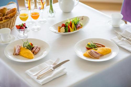 a white table with plates of food on it at Luke Plaza Hotel in Nagasaki