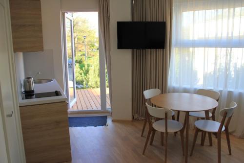 a kitchen and a table and chairs in a room at Baltic Apartments Premium in Palanga