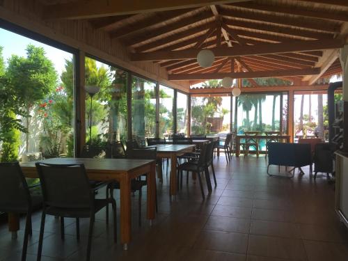 a restaurant with tables and chairs and windows at On Hotel in Adrasan