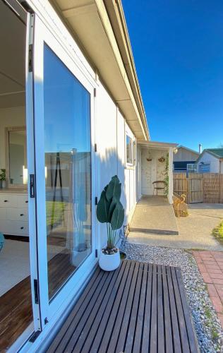 a sliding glass door of a house with a potted plant at Sun-kissed Spa Retreat in Hastings