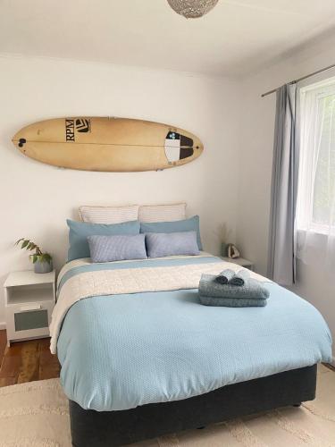 a surfboard hanging above a bed in a bedroom at Sun-kissed Spa Retreat in Hastings