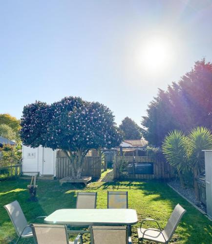 a garden with a table and chairs in the grass at Sun-kissed Spa Retreat in Hastings