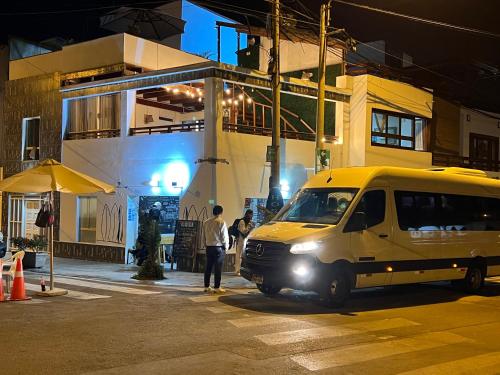 a van parked in front of a building at night at Surfer Hostel El Quilla Punta Hermosa in Punta Hermosa