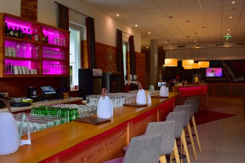 a bar in a restaurant with chairs and wine glasses at Sporthotel Zederhaus im Lungau in Zederhaus