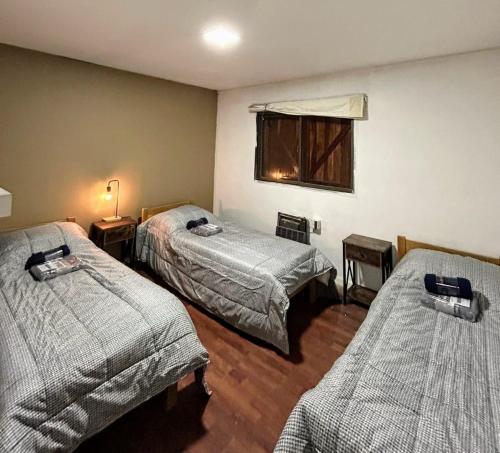 a hotel room with two beds and a window at Los penitentes, edificio juncal dpto 1 in Los Penitentes