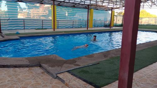 two people swimming in a swimming pool at Hospedaje Centro Huequén in Angol