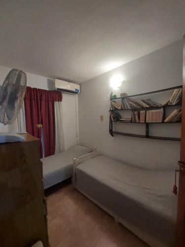 Una pequeña habitación con dos camas y un ventilador. en Casa Libertad, en Chumillo