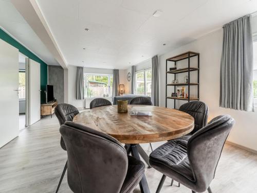 a dining room with a wooden table and chairs at t Kaatsheuveltje 6 in Sprang-Capelle