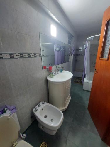 Un baño con un lavabo blanco y un inodoro. en Casa Libertad, en Chumillo