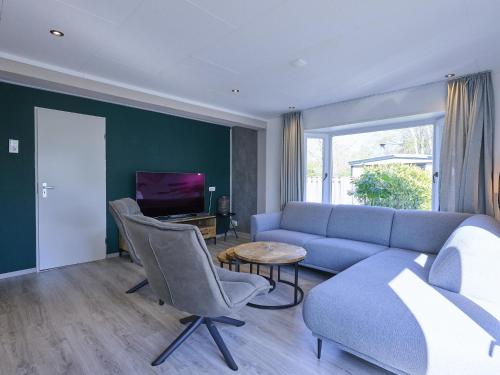a living room with a couch and chairs and a tv at t Kaatsheuveltje 6 in Sprang-Capelle