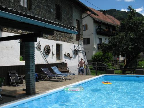 a man standing in front of a house with a swimming pool at Das alte Brauhaus in Seeboden