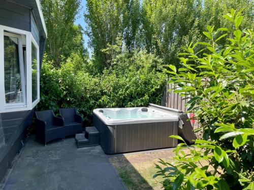 a hot tub in a yard next to a house at t Kaatsheuveltje 6 in Sprang-Capelle