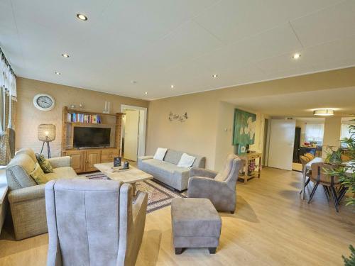 a living room with a couch and a tv at Landsraderhöfke - 1 in Heijenrath