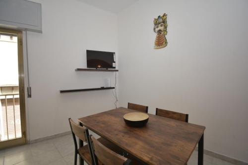 a dining room with a wooden table and chairs at Cuore di Casa 1 in Ragusa