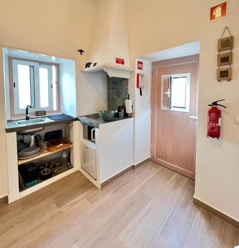 a kitchen with a sink and a counter top at Casa Fidalgo in Santo António da Terrugem