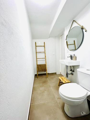 a bathroom with a toilet and a sink and a mirror at Casa Fidalgo in Santo António da Terrugem