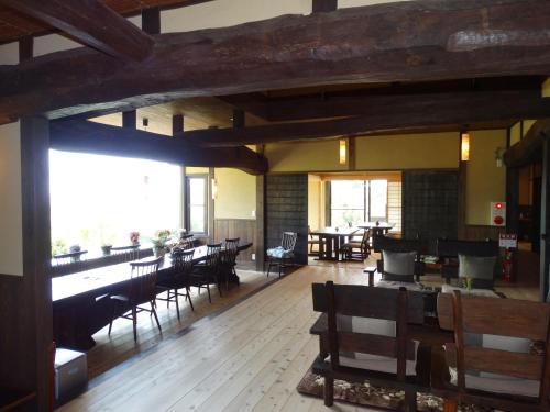 Aunsanbo في Misakicho: غرفة طعام مع طاولات وكراسي في مبنى