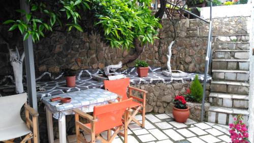 a table and chairs on a patio with a stone wall at Paraskevi's Luxury Studios in Parga