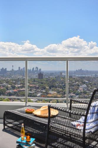 a balcony with a table and chairs and a view of the city at Meriton Suites Bondi Junction in Sydney