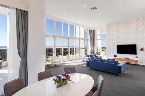 a living room with a blue couch and a table at Meriton Suites Bondi Junction in Sydney