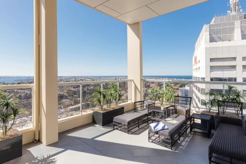 a balcony with chairs and tables on a building at Meriton Suites Bondi Junction in Sydney