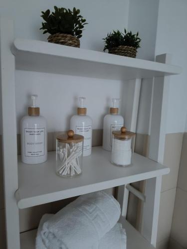 a shelf with four bottles of soap and towels at Casa Papel y Pluma in Cazorla