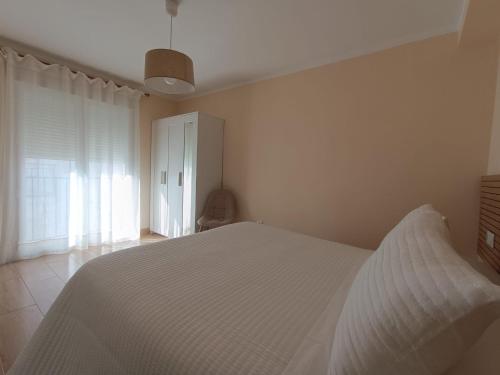 a bedroom with a white bed and a window at Casa Papel y Pluma in Cazorla