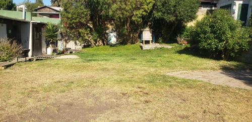 a yard with a grass field and a house at Cabañas Pozo Azul in El Quisco