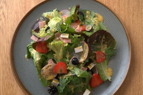 a salad on a blue plate on a table at Amaranto Bacalar Hotel Boutique in Bacalar