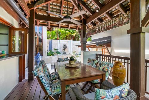 an outdoor patio with a wooden table and chairs at Far Pavilions - An Intimate Bali-style Haven in Port Douglas