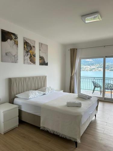a bedroom with a large bed and a balcony at Bellanti in Herceg-Novi