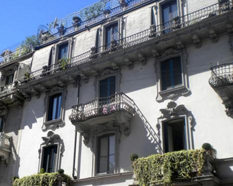 a white building with balconies and plants on it at Lepetit Milano in Milan